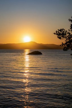 Güney Brezilya 'da Florianopolis' te gün batımı manzarası. Deniz kıyısındaki sahil yolunda. Doğa. Denizde kayalar. Dağlar.