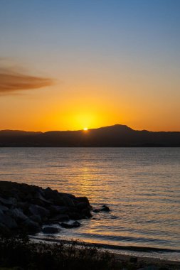 Güney Brezilya 'da Florianopolis' te gün batımı manzarası. Deniz kıyısındaki sahil yolunda. Doğa. Denizde kayalar. Dağlar.