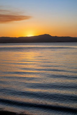 Güney Brezilya 'da Florianopolis' te gün batımı manzarası. Deniz kıyısındaki sahil yolunda. Doğa. Denizde kayalar. Dağlar.