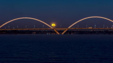 The moon sunset over the JK Bridge in Brasilia, Brazil. Supermoom.