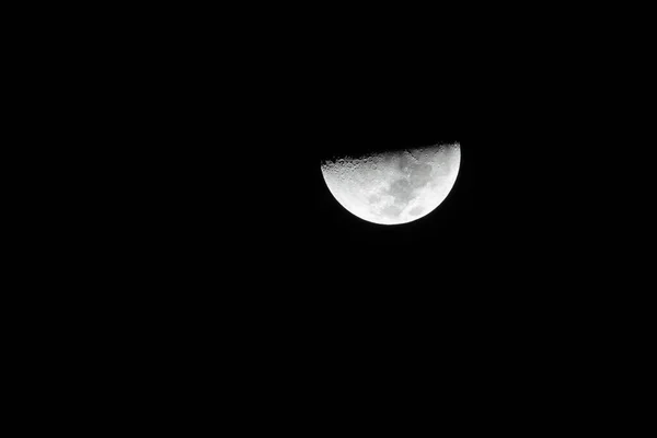 The moon in the quarter on a black background. nature. Phase of moon.