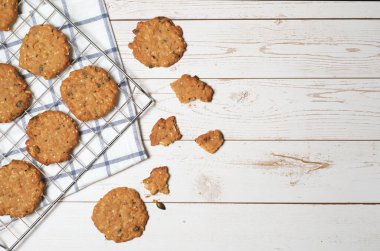 Soğutma rafında balkabağı tohumu ve susamlı kurabiye ve beyaz ahşap arka planda peçete ve sağda coppy alanı.