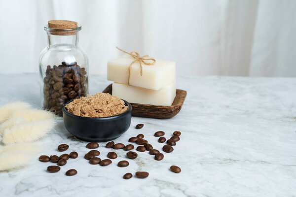 Close up coffee scent salt scrub with coffee beans and bath soap and a glass bolttle of coffee with copy space, Aroma therapy with cafein concept.