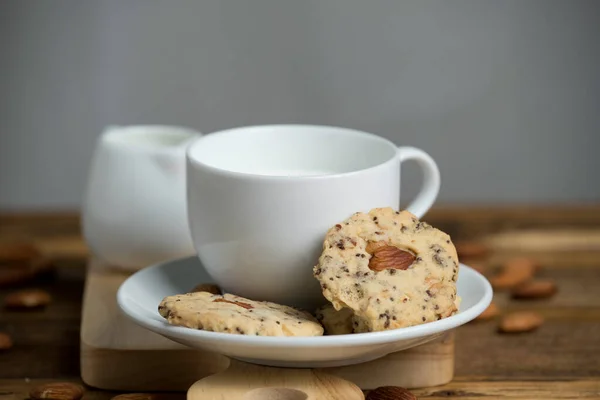 Close Almond Sesame Cookies White Cup Milk Wooden Plate — Stock Photo, Image