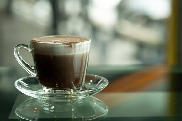 Cam Masada Bir Fincan Sıcak Çikolata Bulanık Arkaplanlı Bir Parça — Stok fotoğraf