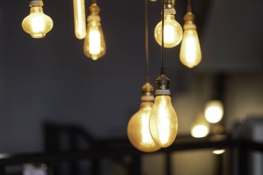Lambanın sıcak ışığı altında klasik, Edison retro lambasını çatı katı gri arka planına ayarlayın. Ev dekorasyonu için kavram fikri.