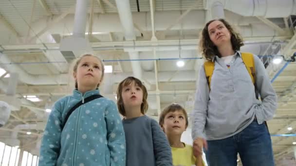 Mãe e crianças pré-escolares passeiam pelo shopping — Vídeo de Stock