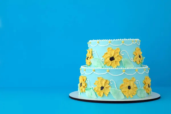 Torta con fiori di girasole su sfondo blu — Foto Stock