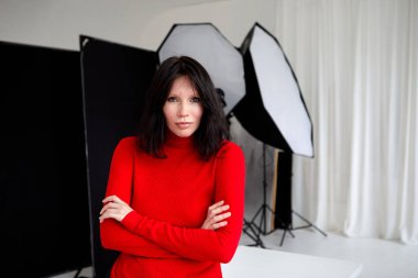 Stüdyoda fotoğraf makinesiyle katlanan kadın.