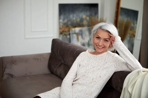 Mujer elegante con el pelo gris en el sofá —  Fotos de Stock