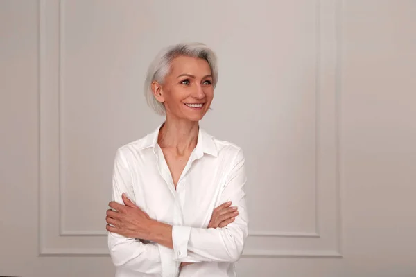 Close up portrait of beautiful older woman standing by wall — Stock Photo, Image