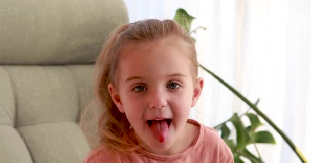 Klein meisje laat haar tong zien — Stockvideo