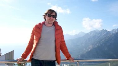 Gülümseyen turist büyük dağlara yaslanıyor