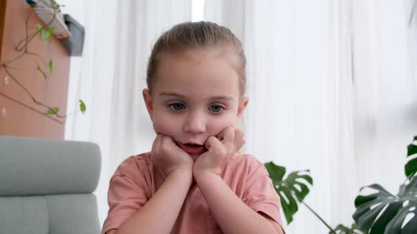 Portræt af lille pige læner sig på hænder taler til kameraet – Stock-video