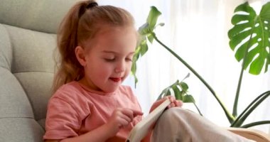 Akıllı telefonuyla video oyunu oynayan sevimli çocuk koltuğunda oturuyor.