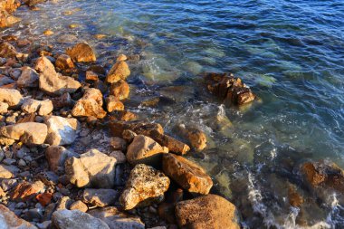 Deniz kenarındaki temiz mavi su ve taşların en üst görüntüsü.