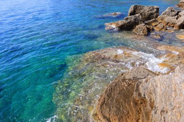 Deniz kenarındaki temiz mavi su ve taşların en üst görüntüsü.