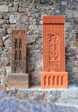 Ermenistan 'daki Geghard Manastırı' nın duvarları yakınında çeşitli boyutlarda antik haçkarlar.