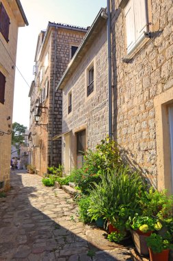 Karadağ 'ın Perast kentinde güneşli bir günde eski tarihi binaların olduğu sokak