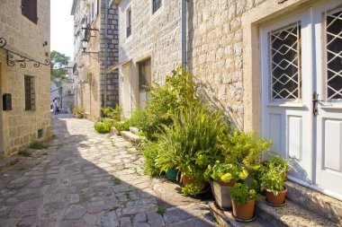 Karadağ 'ın Perast kentinde güneşli bir günde eski tarihi binaların olduğu sokak