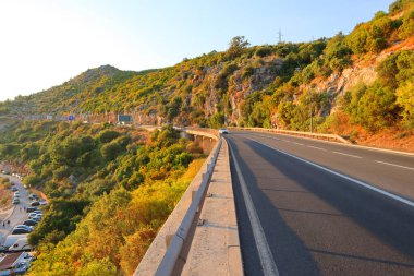 Karadağ 'da Budva ile Sveti Stefan arasındaki yol gün batımında