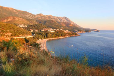 Karadağ 'da Budva ile Sveti Stefan arasındaki bölgede gün batımında resim gibi bir kıyı var.