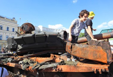 Ukraynalı çocuklar Ukrayna 'nın başkenti Kyiv' deki Sofievskaya Meydanı 'nda paslı askeri teçhizatla oynuyorlar.