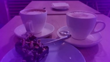 Bir fincan cappuccino ve tatlı, parlak bir arka plan.