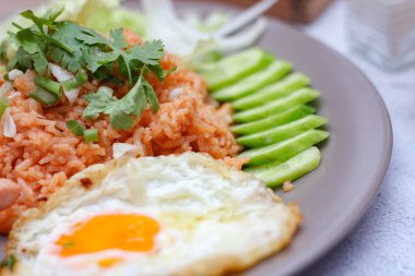 Amerikan pilavı sosis, salatalık, doğranmış sebze ile servis edilir. Tayland baharatlı beyaz bir masada gri bir tabakta..