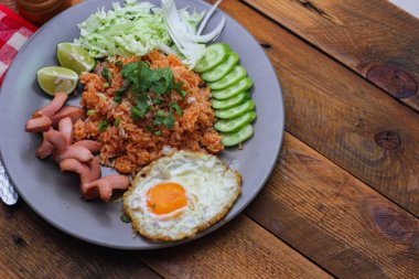 Amerikan pilavı sosis, salatalık ve doğranmış sebzelerle servis edilir Tayland 'da baharatlı kesilmiş bir masada gri bir tabakta..