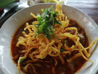 Kuzey Tarzı Körili Erişte Çorbası. Kuzeydeki Tayland halkının yiyeceği. Dilimlenmiş kırmızı soğanlı, limonlu beyaz bir bardakta servis edilir..