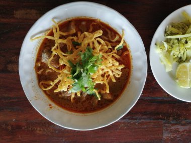 Kuzey Tarzı Körili Erişte Çorbası. Kuzeydeki Tayland halkının yiyeceği. Dilimlenmiş kırmızı soğanlı, limonlu beyaz bir bardakta servis edilir..
