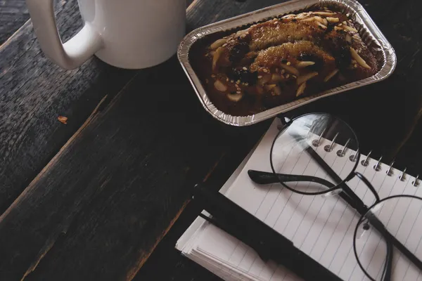 Bolo Banana Uma Mesa Madeira Preta Com Livro Notas Óculos — Fotografia de Stock