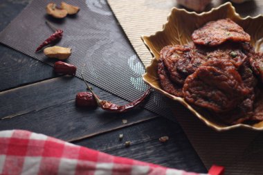 Siyah ahşap bir masaya konmuş yaprak şeklinde bir tabakta servis edilen kızarmış balık ezmesi topları..