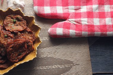 Siyah ahşap bir masaya konmuş yaprak şeklinde bir tabakta servis edilen kızarmış balık ezmesi topları..