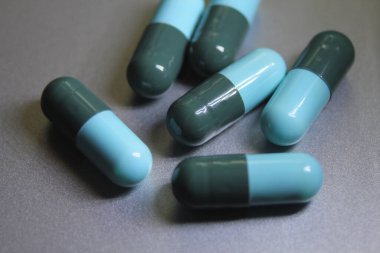 Mavi-yeşil hap kapsülleri gümüş bir masaya yerleştirildi..
