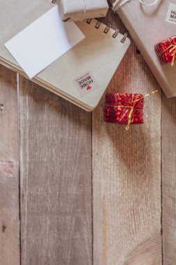 Hediye kutusu Tahta bir masa üzerinde kahverengi geri dönüşümlü kağıt ve not defteri kullanın.