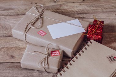 Hediye kutusu Tahta bir masa üzerinde kahverengi geri dönüşümlü kağıt ve not defteri kullanın.