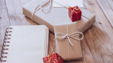 Hediye kutusu Tahta bir masa üzerinde kahverengi geri dönüşümlü kağıt ve not defteri kullanın.