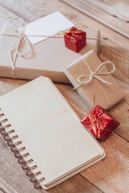 Hediye kutusu Tahta bir masa üzerinde kahverengi geri dönüşümlü kağıt ve not defteri kullanın.