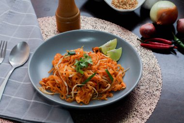 Tayland Gıda Pad Thai 'si (Tayland ulusal yemeği) Gri bir tabakta limon ve süslemeli Tayland yemeği.