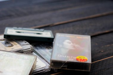 Bangkok, Tayland - 23 Haziran 2021: 90 Beatles, John Lennon ve Nirvana 'nın kasetleri siyah ahşap bir zeminde. ABD 'de.