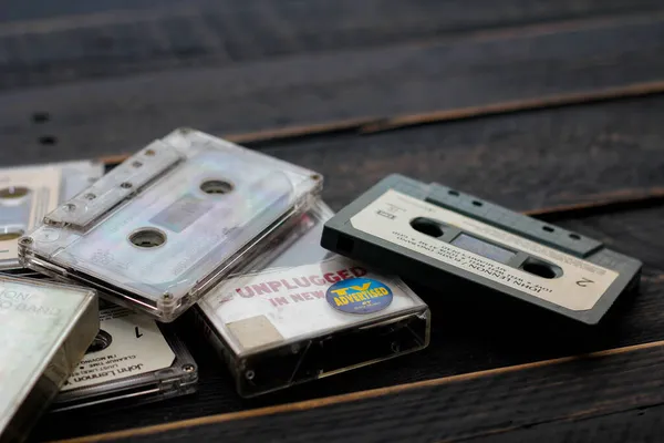 stock image Bangkok, Thailand - June,23 2021 : 90's cassette tapes of The Beatles, John Lennon and Nirvana on a black wooden floor. in USA.