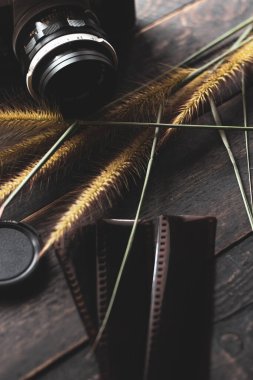 Retro film kamerası ve negatif film siyah ahşap bir masada.