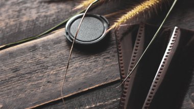 Retro film kamerası ve negatif film siyah ahşap bir masada.