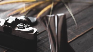 Retro film kamerası ve negatif film siyah ahşap bir masada.