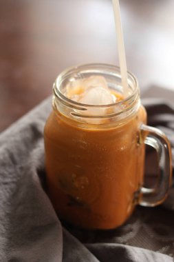 Süt çayı ya da Tayland çayı. Doğal renkte bir ahşap masada servis edilir..