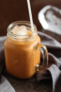 Süt çayı ya da Tayland çayı. Doğal renkte bir ahşap masada servis edilir..