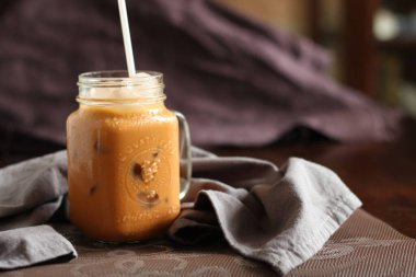 Süt çayı ya da Tayland çayı. Doğal renkte bir ahşap masada servis edilir..