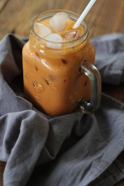 Tahta masada servis edilen sütlü çay ya da Tayland çayı.